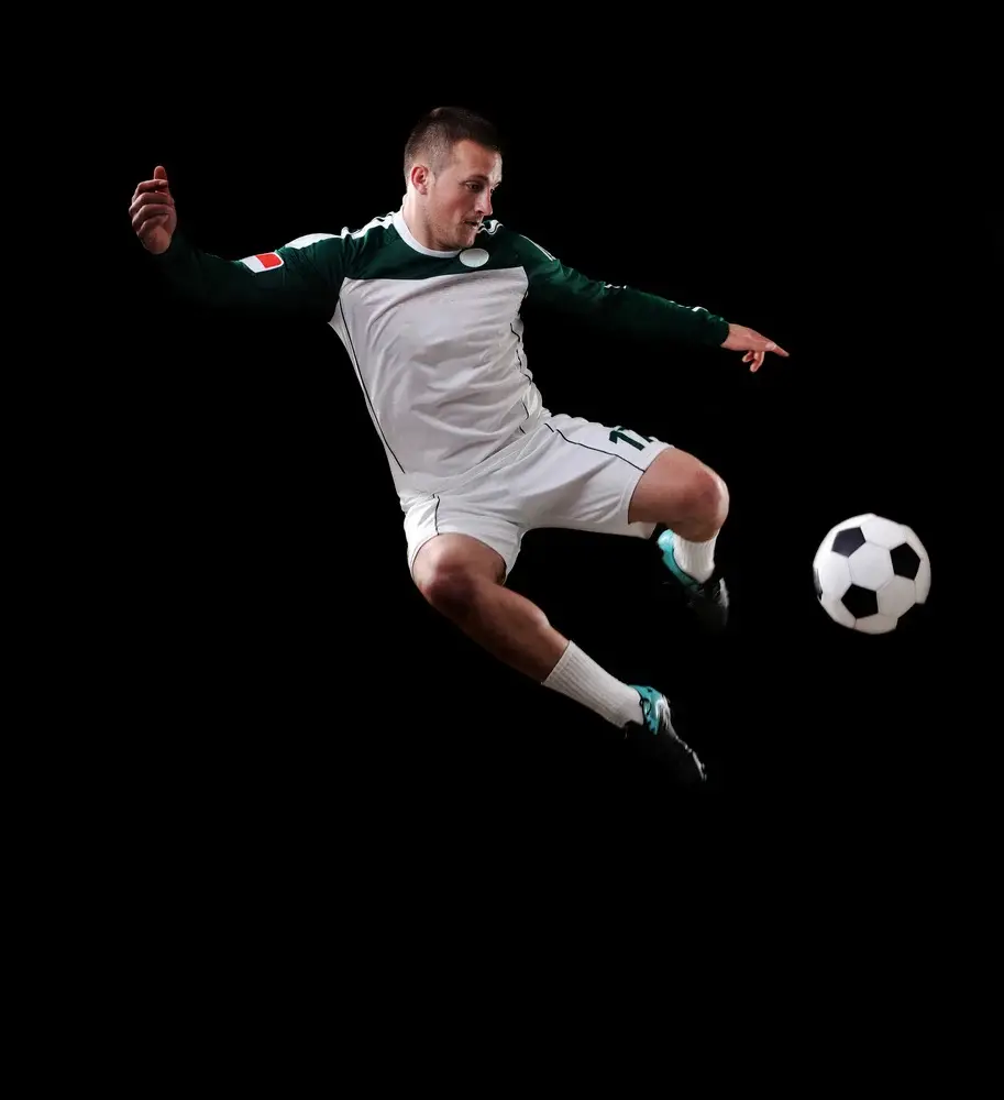 Soccer player in the air over black background
